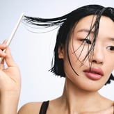 Un gros plan beauté centré sur une femme asiatique aux cheveux noirs coupés au carré.