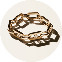 Bracelet à maillons rectangulaires en or jaune incrusté de diamants, posé sur un fond clair avec un jeu d'ombres portée