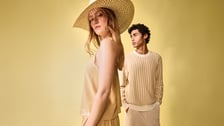 Modèles homme et femme posant pour une collection de mode estivale sur fond jaune.