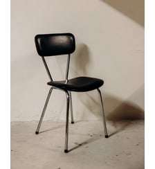 Chaise en cuir synthétique noir au cadre chromé Alma N°1971- Produit chiné Debongout