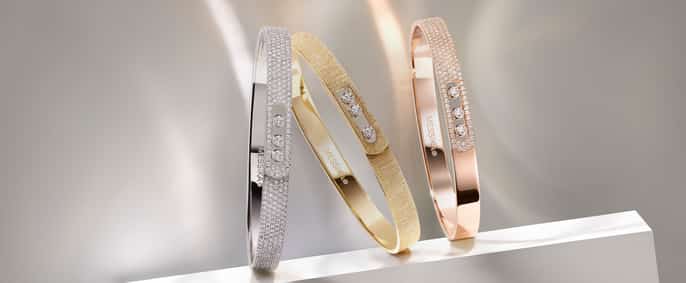 Une vue rapprochée et élégante de trois bracelets joncs de la collection de bijoux Messika